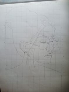 a drawing of a woman's face is shown on a piece of white paper