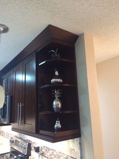 a kitchen with dark wood cabinets and marble counter tops