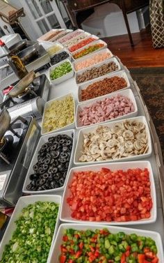 a buffet table filled with lots of different types of vegetables and meats on trays