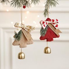 two ornaments hanging from a christmas tree with ribbons and bows on them, one is shaped like a house