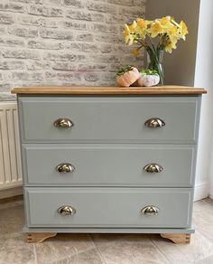 a gray dresser with some yellow flowers on top