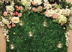 an artificial green wall with flowers and greenery