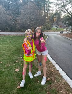 two young women dressed up in costumes posing for the camera with their hands painted yellow and pink