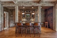 a kitchen with wood floors and wooden bar stools