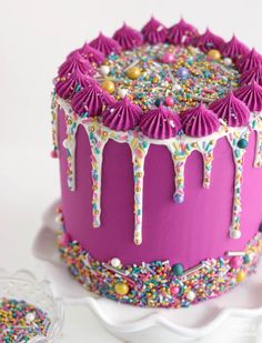 a pink cake with sprinkles and decorations