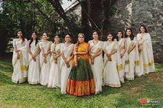 a group of women standing next to each other on top of a lush green field