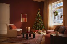 a living room filled with furniture and a christmas tree in front of a large window