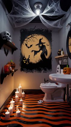 a bathroom decorated for halloween with candles on the floor and decorations hanging from the ceiling