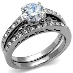 a wedding ring set with an oval cut diamond and round diamonds on the band, in white gold