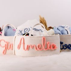 three baskets with personalized items in them sitting on a white tablecloth covered surface