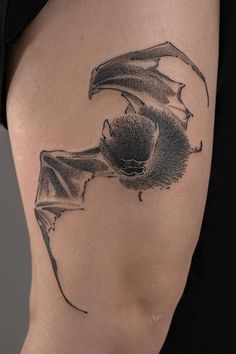 a woman's thigh with a bat tattoo on it