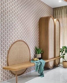 a wooden bench sitting in the middle of a room next to a mirror and potted plant