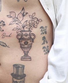 a woman's stomach with flowers in a vase tattoo on her belly and the word love written below it