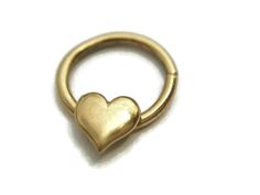 I made this lovely septum ring entirely from sterling silver and plated it with 24k gold. It features a sweet little heart measuring approximately 6mm. I finished it with a shiny high polish. Twist open and close to keep the circle shape, the ends are smooth for easy insertion. Can be worn in a variety of piercings. I can make the ring in various thicknesses which you can choose at check out. Sizes measure as follows: 14 gauge = 1.63mm 16 gauge = 1.29mm 18 gauge = 1.02mm 20 gauge = .812mm Comes Tiny Gold Septum Ring As Gift, Tiny Gold Septum Ring Gift, Nickel-free Gold Septum Ring For Gift, Dainty Gold Septum Ring As Gift, Heart Nose Rings, Septum Hoop, Golden Heart, Nose Hoop, Septum Piercing