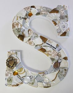 the letter s is made up of many different types of glass and metal items, including beads