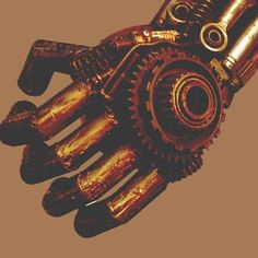 a hand made out of gold colored metal parts with gears attached to the wrist and fingers