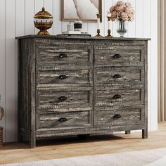 an old wooden dresser with drawers and pictures on the wall