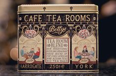 a tea box that has some writing on the front and side of it with an image of two people sitting at a table