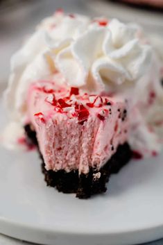 a piece of cake on a plate with whipped cream and peppermint toppings