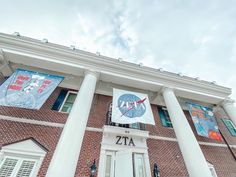 a tall brick building with banners on the front and side of it's entrance