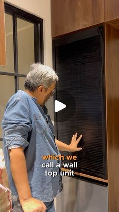 a man standing in front of a window with the words which we call a wall top unit