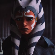 a woman with painted on her face wearing a star wars outfit and hood over her head