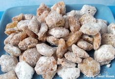 a blue plate topped with lots of powdered sugar coated dog treats on top of a table