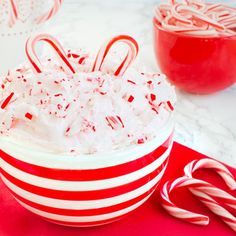 a bowl filled with candy canes on top of a table