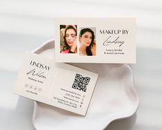 two business cards sitting on top of a white plate