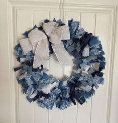 a blue and white wreath hanging on the front door