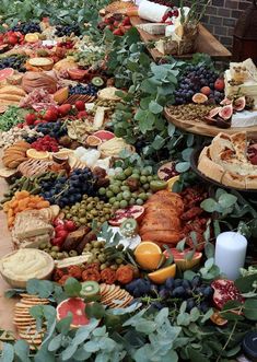 a table filled with lots of different types of cheeses and fruit on top of it