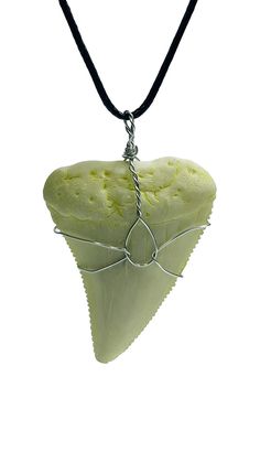 a piece of food that is hanging from a string on a necklace with a black cord