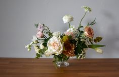 a vase filled with flowers on top of a wooden table