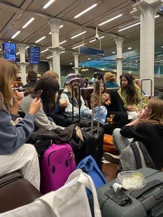 many people are waiting for their luggage in an airport terminal while others sit and stand around