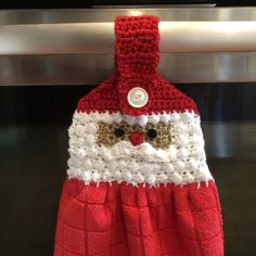 a red and white santa claus towel hanging on a rack in front of a stove