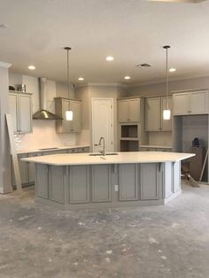 an empty kitchen with white cabinets and gray counter tops in a new construction home that is being built