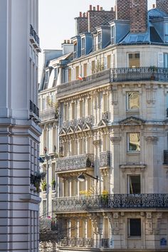 an old building with balconies and balcony railings in the foreground, surrounded by other buildings