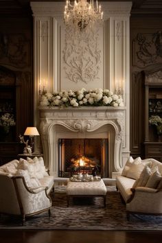 a living room filled with furniture and a fire place under a chandelier in front of a fireplace