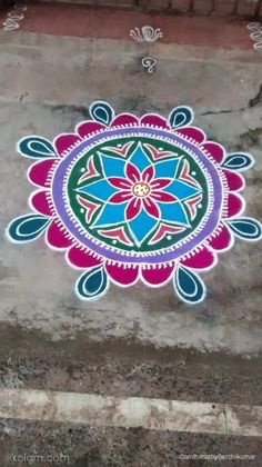 an image of a colorful flower design on the ground