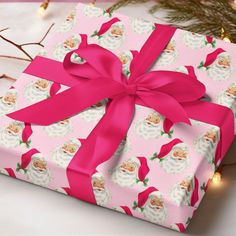 a pink present wrapped in paper with a bow