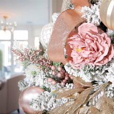 a christmas tree with pink flowers and gold ornaments in the center, along with other holiday decorations