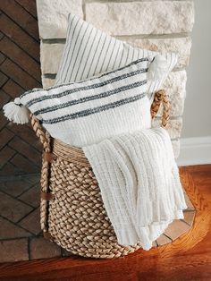 a basket filled with pillows sitting on top of a wooden floor