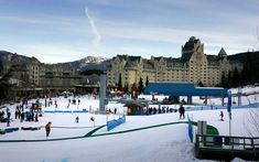 people are skiing and snowboarding on the slopes in front of a castle like building