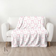 a white couch with pink bows on it in front of a white wall and wooden floor