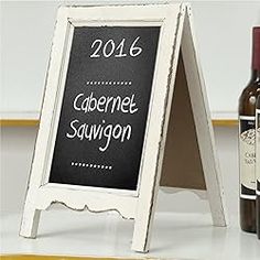 a chalkboard sign next to bottles of wine