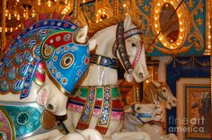 an ornate carousel with two horses on it's sides and lights in the background