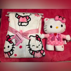 a hello kitty blanket and stuffed animal laying on a bed