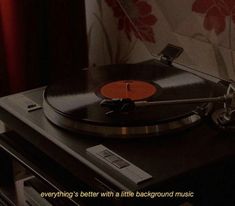 an old record player sitting on top of a turntable in front of a curtain