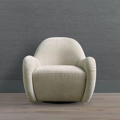 a white chair sitting on top of a hard wood floor next to a gray wall