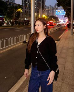 a woman standing on the side of a road